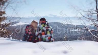 年轻人穿着时尚的冬季服装。 英俊的小男孩坐在他可爱的女朋友的额头上亲吻他